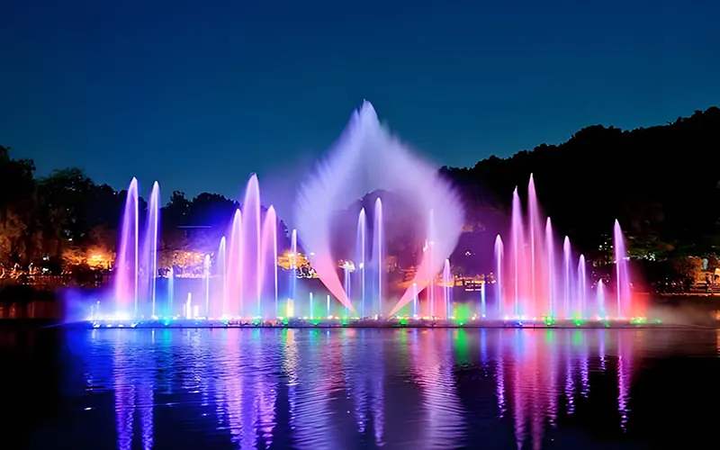 Dancing water fountain with synchronized LED lights and music performance at night