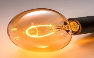 Lumen to Watts conversion chart illustrated with a light bulb showing brightness and energy consumption comparison